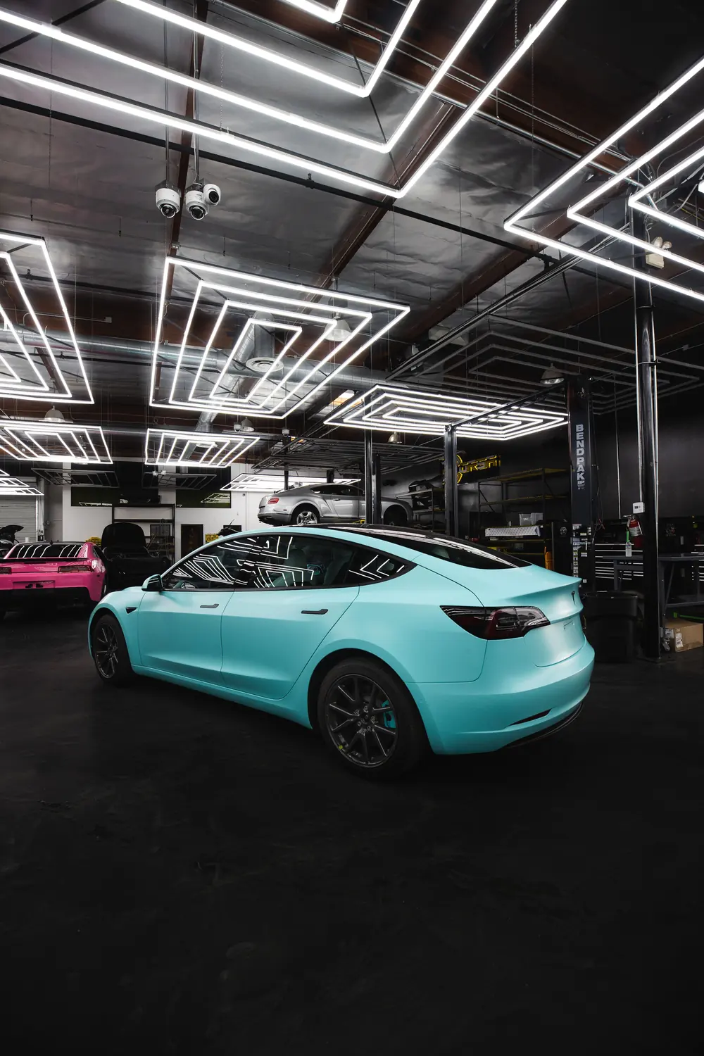 Blue car displayed inside a modern illuminated garage